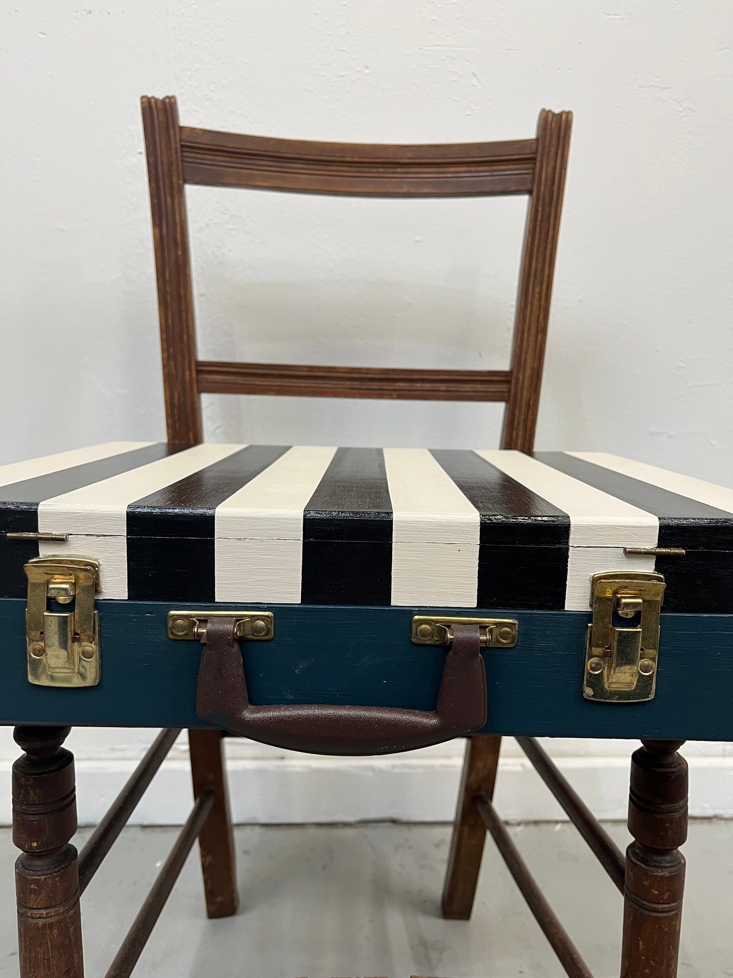 Vintage artist painters box painted with black and white stripes on the lid and dark green on the lower half.